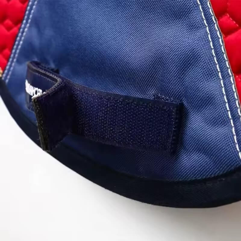 Close-up of a blue and red fabric pad with a strap and brand name on a white background
