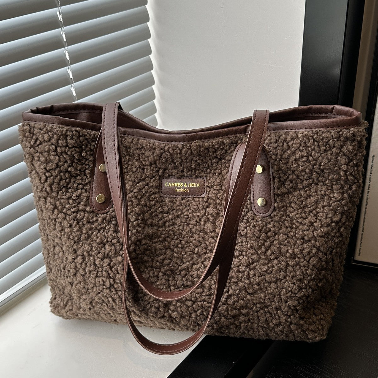 Brown textured tote bag with visible brand logo on a surface.