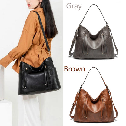Three handbags in gray, black, and brown with a person wearing a brown jacket.