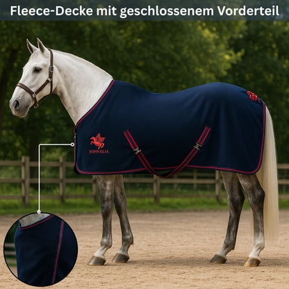 Horse wearing a navy blue fleece blanket with red trim in an outdoor setting