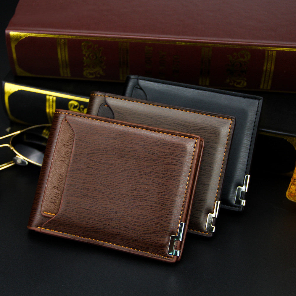 Three leather wallets in brown, black, and coffee on a dark surface with books and glasses in the background.