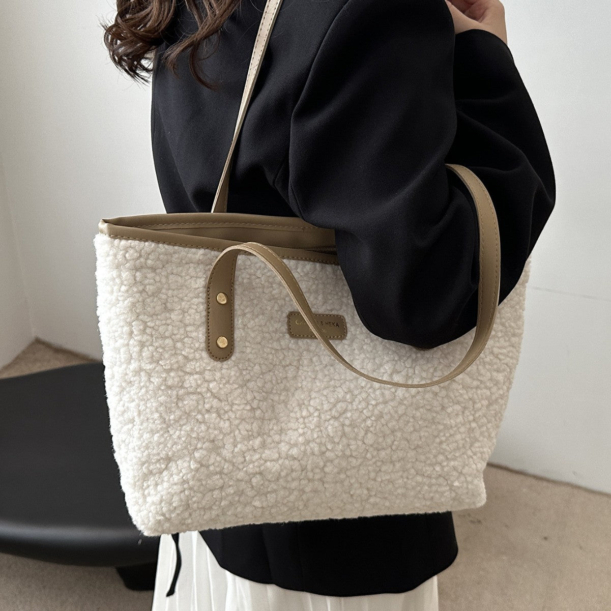Woman carrying a beige plush tote shoulder bag
