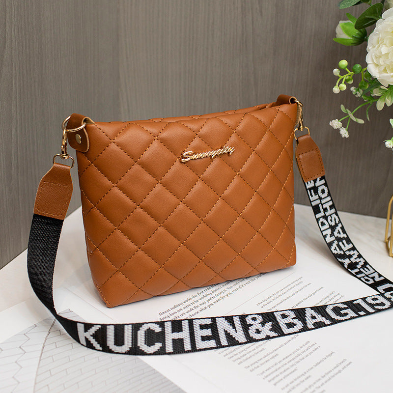 Brown diamond grid shoulder bag with wide printed shoulder strap and zip closure.