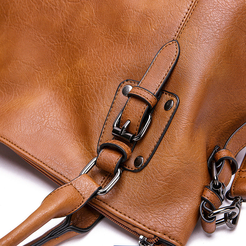 Close-up of vintage PU leather tote bag hardware and strap attachment.
